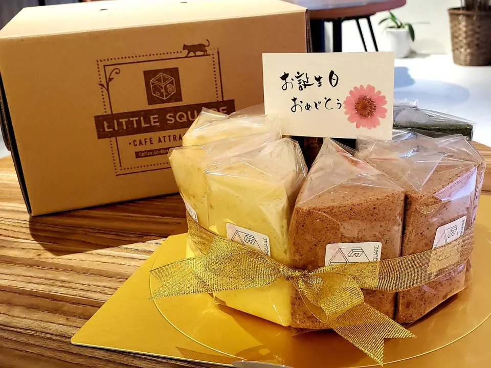 リボンを掛けた記念日のホールシフォンケーキと LITTLE SQUARE の箱